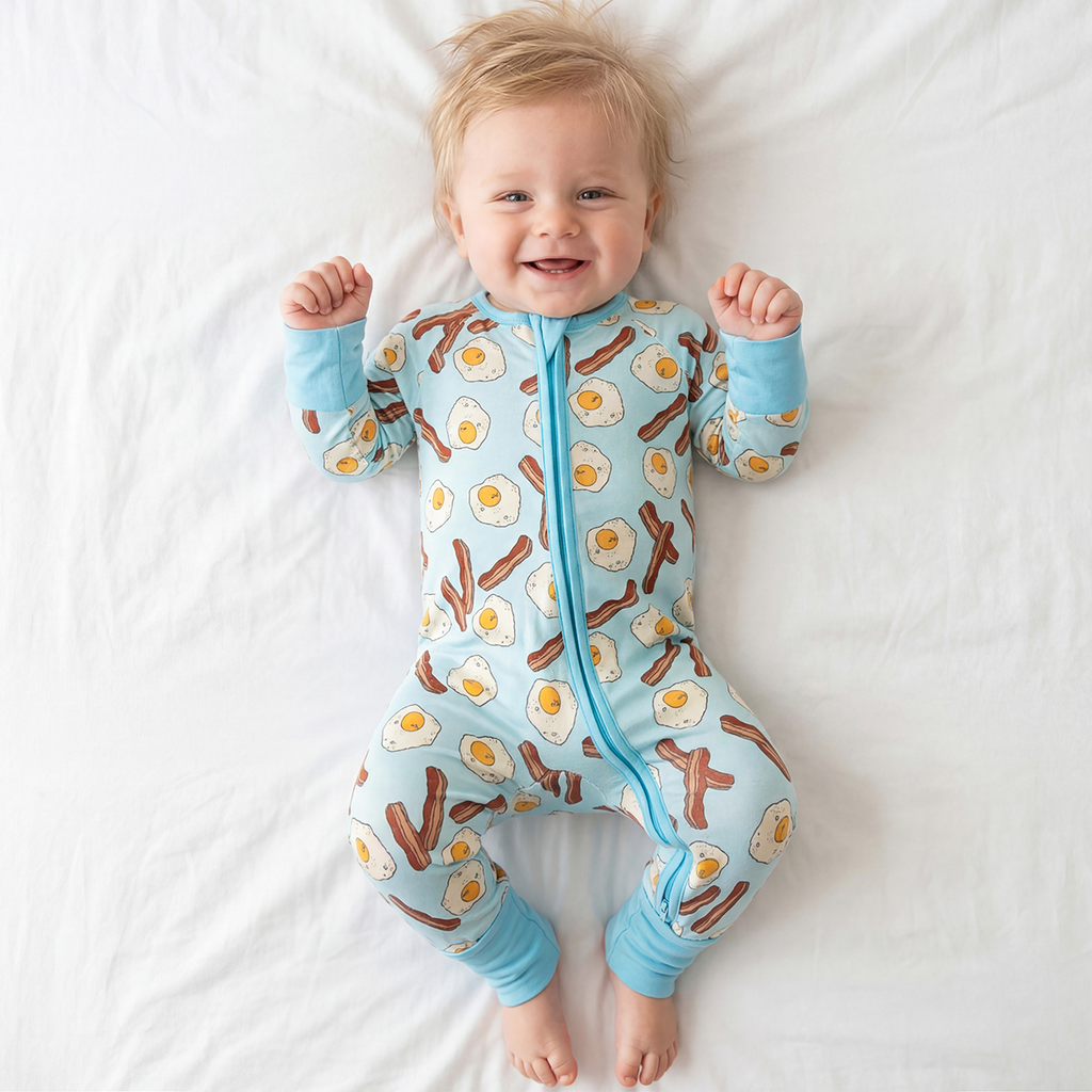 Baby wearing a onesie with breakfast-themed design on a white background
