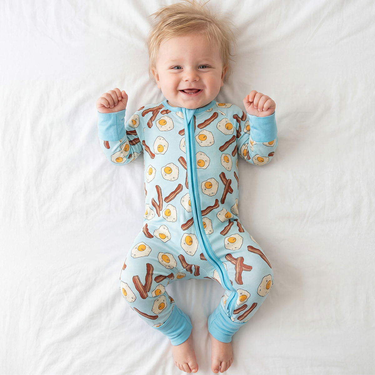 Baby wearing a onesie with breakfast-themed design on a white background